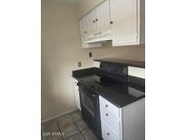 The kitchen features white cabinets, a dark countertop, and a black oven range at 653 W Guadalupe Rd # 2019, Mesa, AZ 85210