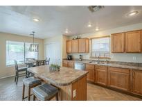 Spacious kitchen with an island, bar stools, and stainless steel appliances at 69 W Grey Stone St, San Tan Valley, AZ 85143