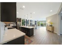 Open floor plan features large kitchen island, hardwood floors and easy access to living and dining areas at 8419 S 164Th Dr, Goodyear, AZ 85338