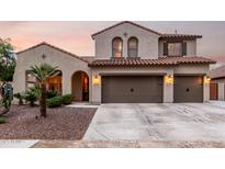 Charming two-story home featuring a three car garage, desert landscaping, and a red tile roof at 12300 N 142Nd Ln, Surprise, AZ 85379