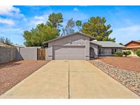 Charming single-Gathering home featuring desert landscaping, an attached two-car garage, and an enclosed courtyard entrance at 16412 N 33Rd Ave, Phoenix, AZ 85053