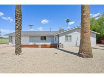 Charming single-story home with desert landscaping, white trim, grey paint, and palm trees at 2045 N 68Th St, Scottsdale, AZ 85257