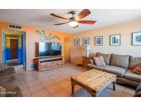Comfortable living room with a ceiling fan, tile flooring, and a large entertainment center for modern living at 2534 N Mitchell St. St, Phoenix, AZ 85006