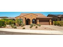 Charming single-story home with stucco exterior, tile roof, landscaped front yard, and a two-car garage on a sunny day at 30876 N 128Th Dr, Peoria, AZ 85383