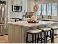 Bright kitchen features quartz island with seating, stainless steel appliances, and modern finishes at 5011 E Nisbet Rd, Scottsdale, AZ 85254