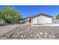 Charming single-story home featuring a stucco facade and a rock garden in the front yard at 646 W Grove Cir, Mesa, AZ 85210