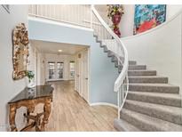Grand foyer features a curved staircase, wood floors, and elegant decor, creating a stunning first impression at 7315 E Arlington Rd, Scottsdale, AZ 85250