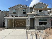 New construction shows scaffolding, a driveway, and a two-story structure with a garage, and a bright, blue sky above at 7444 W Buckhorn Trl, Peoria, AZ 85383