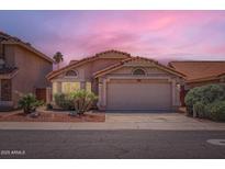 Charming single-Gathering home with a two-car garage and desert landscaping under a beautiful dusk sky at 7709 W Tonto Dr, Glendale, AZ 85308