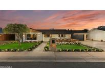Charming single-story home with lush lawn, beautiful landscaping, and a lovely front porch at 8419 E Rancho Vista Dr, Scottsdale, AZ 85251