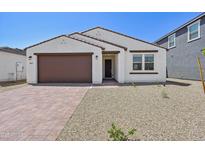 Inviting single story home with a two car garage, paver driveway, neutral-toned stucco and brown trim at 9547 W Parkway Dr, Tolleson, AZ 85353