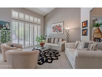 Bright living room featuring vaulted ceilings, plantation shutters, neutral decor and large windows at 11651 E Appaloosa Pl, Scottsdale, AZ 85259
