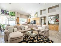 Open living room featuring sectional sofa, high ceilings, and artful decor, leading into the kitchen at 11651 E Appaloosa Pl, Scottsdale, AZ 85259