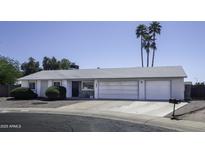 Charming single-story home featuring a three-car garage, low-maintenance landscaping, and mature palm trees at 1209 W Tulane Dr, Tempe, AZ 85283