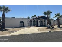 A charming single-story home with a private drive, desert landscaping, and mature palm trees at 12805 W Colter St, Litchfield Park, AZ 85340