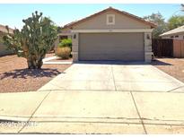 Charming single-story home featuring a two-car garage and desert landscaping at 15023 W Redfield Rd, Surprise, AZ 85379