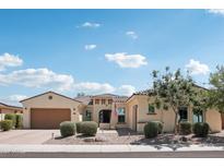Inviting single-story home featuring a well-manicured front yard and a two-car garage, under a partly cloudy sky at 15849 W Alvarado Dr, Goodyear, AZ 85395