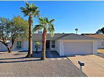Charming single-story home featuring a well-maintained yard, palm trees, and a two-car garage at 5627 W Comet Ave, Glendale, AZ 85302