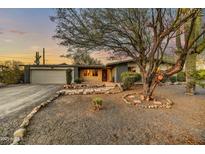 Inviting single-story home with a spacious front yard, mature tree, and desert landscaping at 6002 E Cholla Rd, Cave Creek, AZ 85331