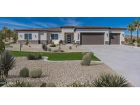 Beautiful desert home featuring a three-car garage, modern architecture, and desert landscaping at 6564 W Apex Ave, Queen Creek, AZ 85144