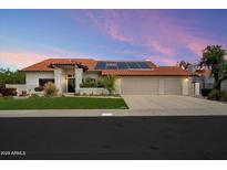 Charming single-story home with a three-car garage, tile roof, solar panels, and well-maintained landscaping at 10510 E Terra Dr, Scottsdale, AZ 85258