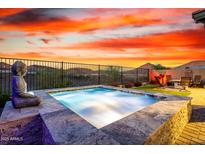 Luxurious pool with elegant stonework, zen accents, and serene landscaping, offering an idyllic outdoor escape at 13384 W Red Range Way, Peoria, AZ 85383