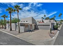 Contemporary home with a desert landscape featuring palm trees and an attached two-car garage at 17289 E Kirk Ln, Fountain Hills, AZ 85268