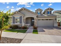 Charming single-Gathering home boasts a well-manicured front yard, stone accents, and a two-car garage at 2644 S Dock St, Gilbert, AZ 85295