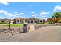 Stunning single-story home with a stone-accented facade and a well-manicured front yard at 18225 W San Juan Ct, Litchfield Park, AZ 85340