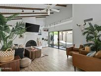 Bright living room boasts vaulted ceilings, wood beams, tiled fireplace, and sliding glass doors to a private patio at 2839 N 61St St, Scottsdale, AZ 85257