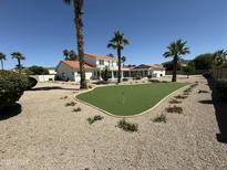 Expansive backyard featuring a lush putting green, desert landscaping and a charming home exterior at 6337 W Deer Valley Rd, Glendale, AZ 85308