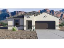 Charming single-story home with a two-car garage and desert landscaping in front at 8519 W Clemente Way, Florence, AZ 85132