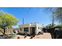 A backyard featuring a brick house, a small outdoor seating arrangement, and a clear blue sky at 1731 E Moreland St, Phoenix, AZ 85006