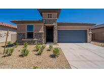 Charming single-story home featuring brick accents, a two-car garage, and low maintenance desert landscaping at 24184 W Gibson Ln, Buckeye, AZ 85326