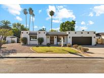 Charming single-story home featuring a desert-landscaped front yard and a spacious two-car garage at 2435 E Jensen St, Mesa, AZ 85213