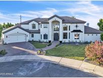 Beautiful two-story white home with a manicured lawn and a brick driveway in a desirable neighborhood at 2662 N Chestnut Cir, Mesa, AZ 85213