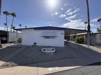 Charming mobile home with covered parking, rock landscaping, and palm tree views at 303 S Recker Rd # 50, Mesa, AZ 85206