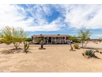Charming single-story home featuring a cozy front porch and desert landscaping under a beautiful sky at 30517 W Lynwood St, Buckeye, AZ 85396