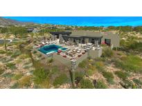 Inviting pool area with ample seating, a fireplace, and desert landscaping create an outdoor oasis at 41639 N 113Th Pl, Scottsdale, AZ 85262