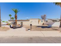 Charming single-story home featuring desert landscaping and mature palm trees for a tranquil outdoor setting at 10472 W Devonshire Ave, Phoenix, AZ 85037