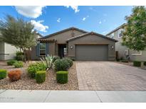 Charming single-story home showcasing a well-manicured lawn, stylish pavers, and a two-car garage at 11623 W Marguerite Ave, Avondale, AZ 85323