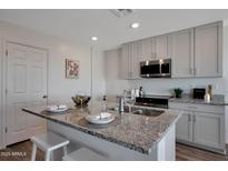 Bright kitchen features a granite island, stainless appliances and stylish white cabinets at 1179 N 13Th St, Coolidge, AZ 85128