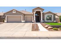 Charming single-story home featuring a well-manicured front yard, tile roof, and a three-car garage at 1932 S Arroyo Ln, Gilbert, AZ 85295