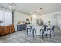 Bright, modern kitchen with white cabinets, stainless steel appliances, and a large center island at 2210 W Calle Del Sol --, Phoenix, AZ 85085