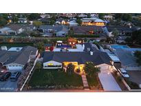 Expansive aerial view showcasing a well-lit home, lush backyard with a pool, and beautiful neighborhood at 3653 E Highland Ave, Phoenix, AZ 85018