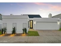 Charming single-story home featuring a crisp white facade, well-manicured lawn, and a modern, black-accented front door at 5318 N 24Th Pl, Phoenix, AZ 85016