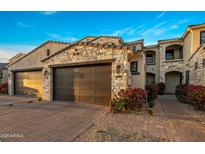 Charming home featuring a stone-accented two-car garage and beautiful landscaping at 6500 E Camelback Rd # 1010, Scottsdale, AZ 85251