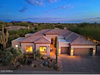 Desert home with a Spanish tile roof, three car garage, and desert landscaping at 6591 E Amber Sun Dr, Scottsdale, AZ 85266