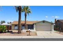 Charming single-story home with a two-car garage and palm trees in the front yard, under a clear blue sky at 7506 W Devonshire Ave, Phoenix, AZ 85033