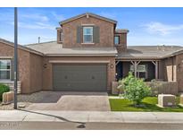 Charming two-story home showcasing a well-manicured lawn and a covered porch area at 1906 N 140Th Dr, Goodyear, AZ 85395